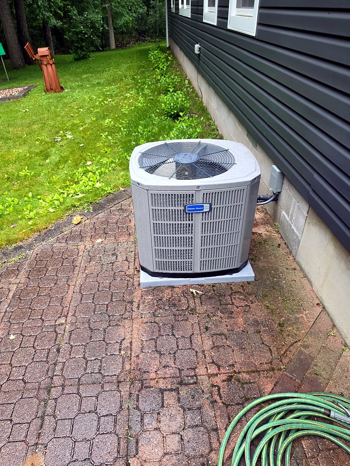 American Standard air conditioner installed on a brick patio